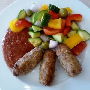 Szárnyas csevap görögsalátán csípős mártógatóssal